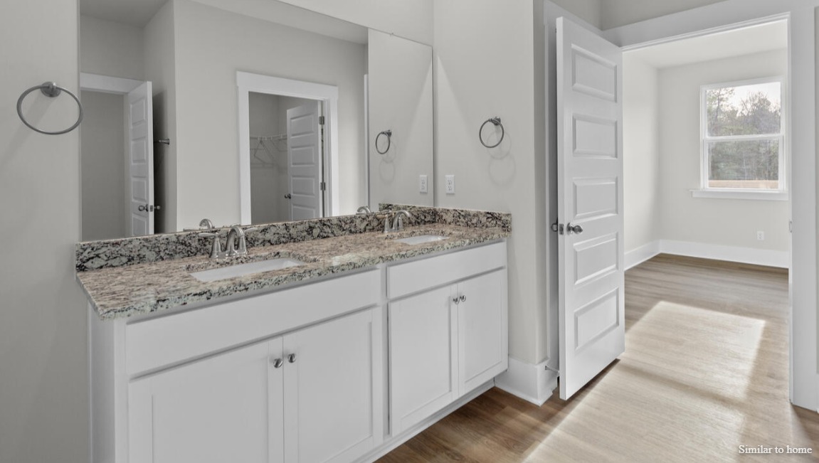 Your primary suite features a 5-foot tiled shower with a frameless glass door and dual vanities for a touch of everyday luxury.