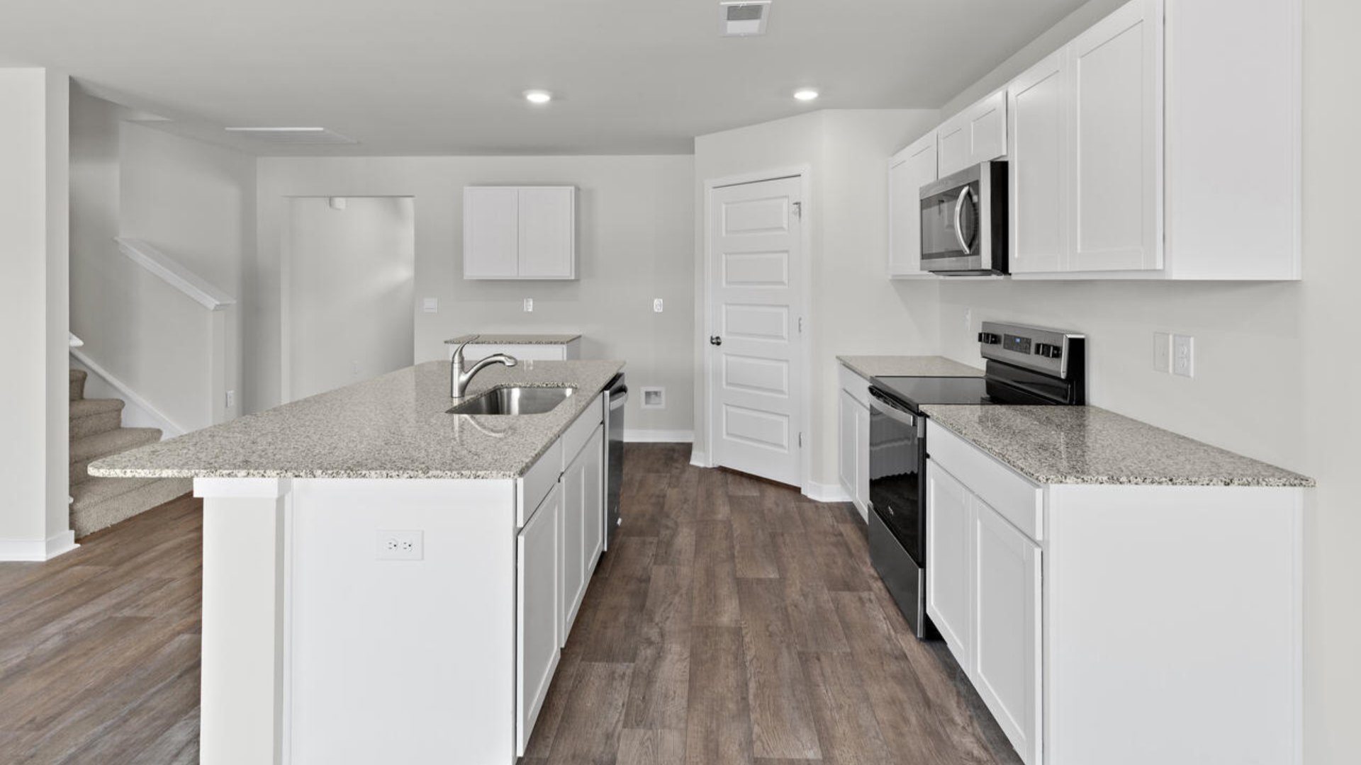 he open-concept kitchen features granite countertops and stainless-steel appliances. The kitchen seamlessly connects to the dining and living areas,