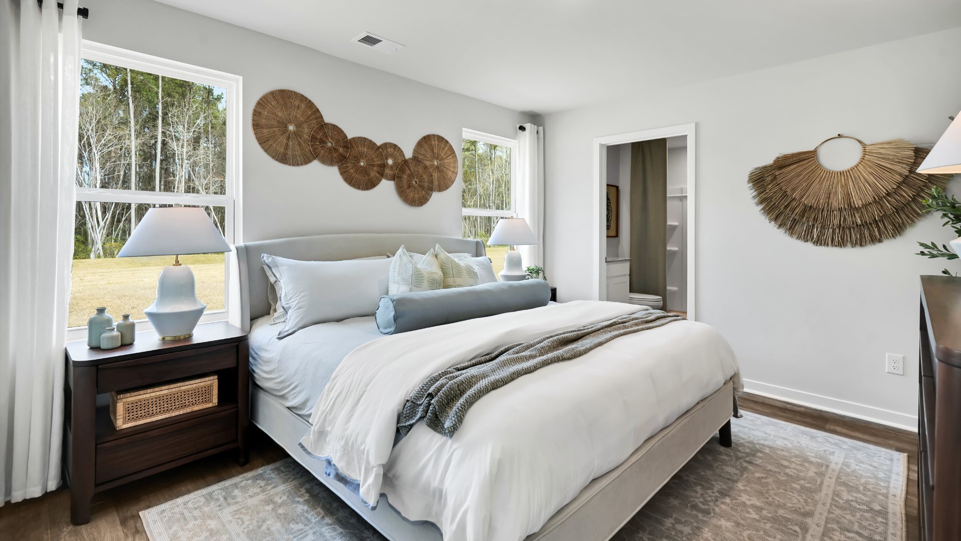 Bedroom One, located at the back of the house for privacy, also has a suite bathroom with double vanity and walk-in closet. Two other bedrooms share a second bathroom. The laundry room is located at the front of home near the two-car garage, quietly away from living areas and bedrooms. Small covered porch at the front.