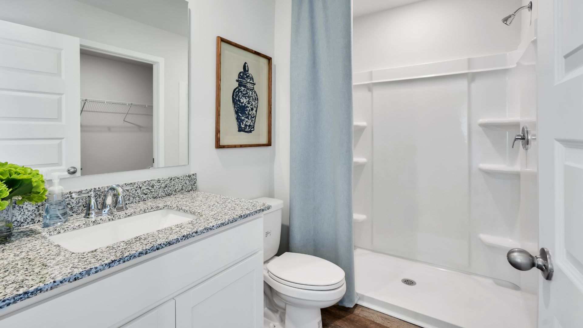 Bedroom One, located at the back of the house for privacy, also has a suite bathroom with double vanity and walk-in closet. Two other bedrooms share a second bathroom. The laundry room is located at the front of home near the two-car garage, quietly away from living areas and bedrooms. Small covered porch at the front.