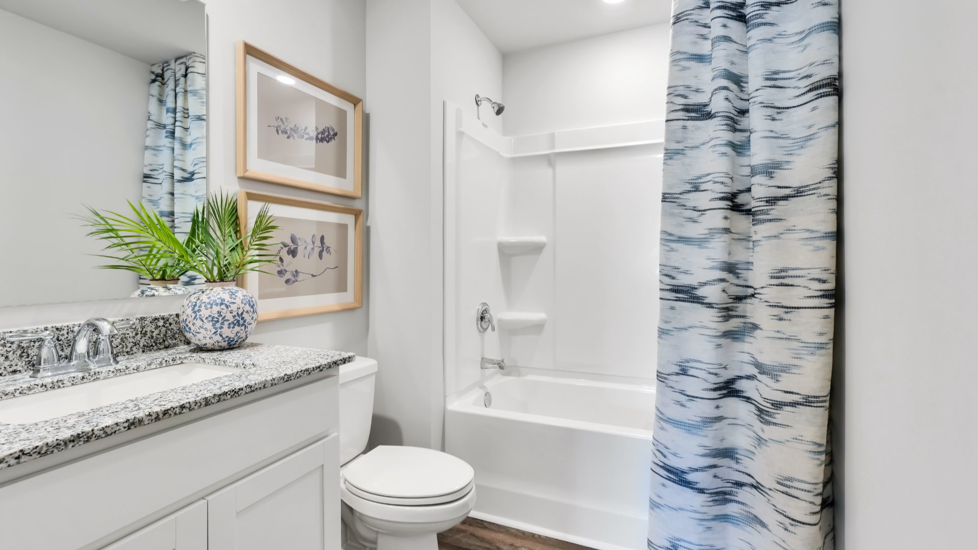 Bedroom One, located at the back of the house for privacy, also has a suite bathroom with double vanity and walk-in closet. Two other bedrooms share a second bathroom. The laundry room is located at the front of home near the two-car garage, quietly away from living areas and bedrooms. Small covered porch at the front.