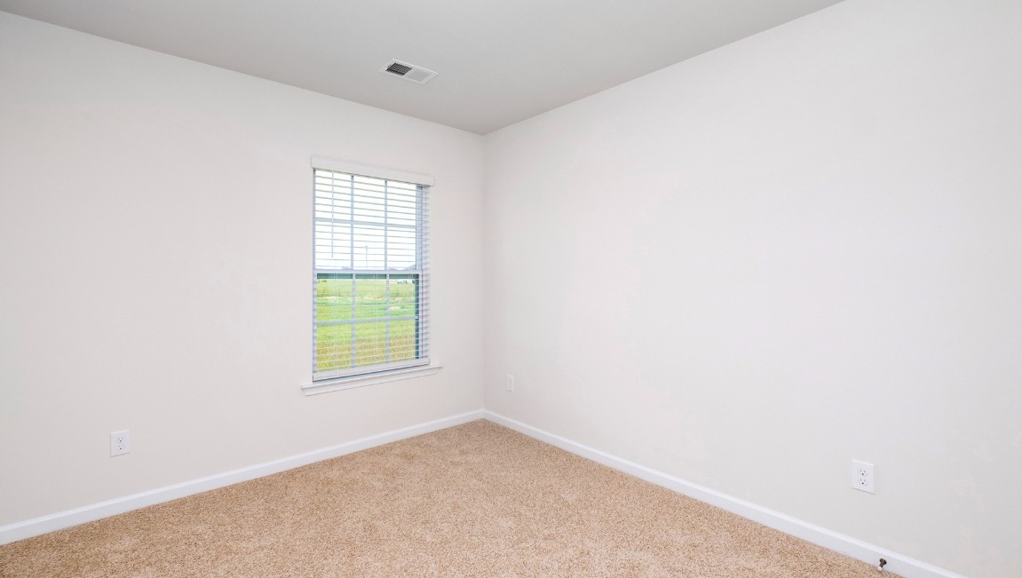 Bedroom One, located at the back of the house for privacy, also has a suite bathroom with double vanity and walk-in closet. Two other bedrooms share a second bathroom. The laundry room is located at the front of home near the two-car garage, quietly away from living areas and bedrooms