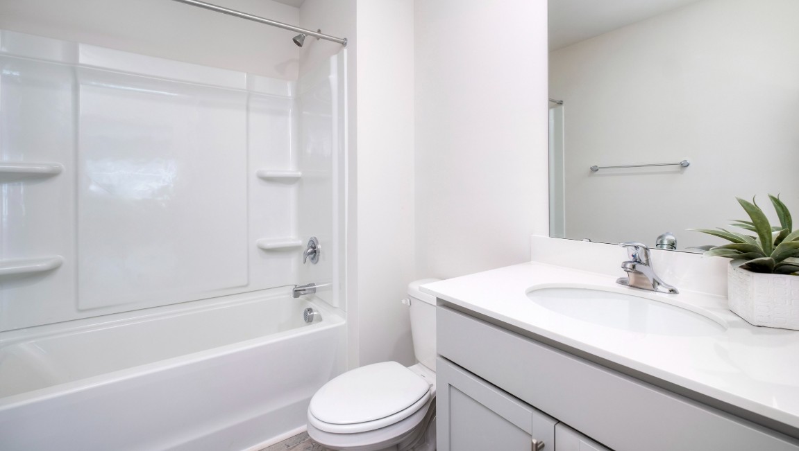 Bedroom One, located at the back of the house for privacy, also has a suite bathroom with double vanity and walk-in closet. Two other bedrooms share a second bathroom. The laundry room is located at the front of home near the two-car garage, quietly away from living areas and bedrooms