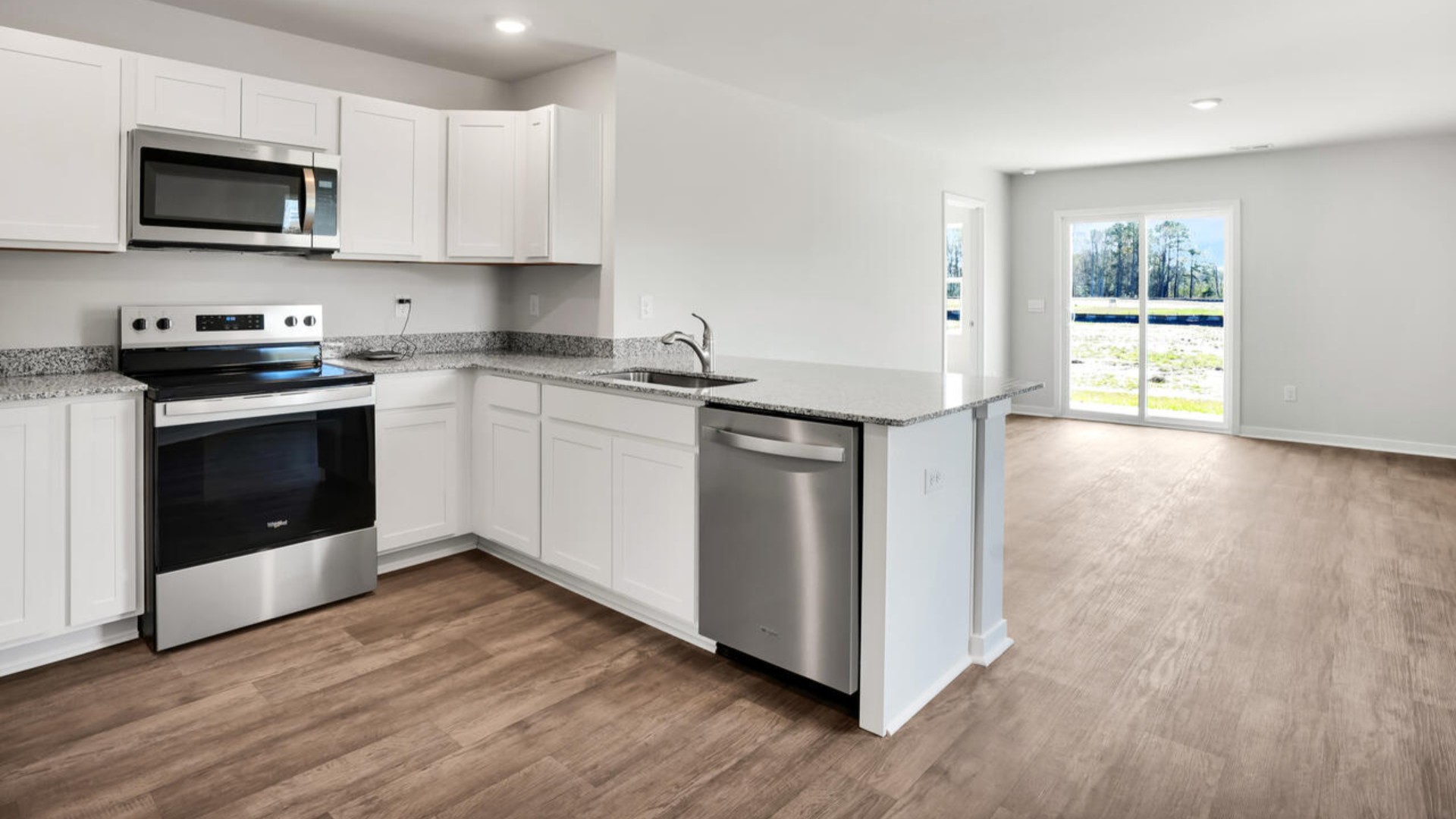 The kitchen is equipped for both efficiency and style with all stainless-steel appliances, including a range, built-in dishwasher, refrigerator, and microwave.