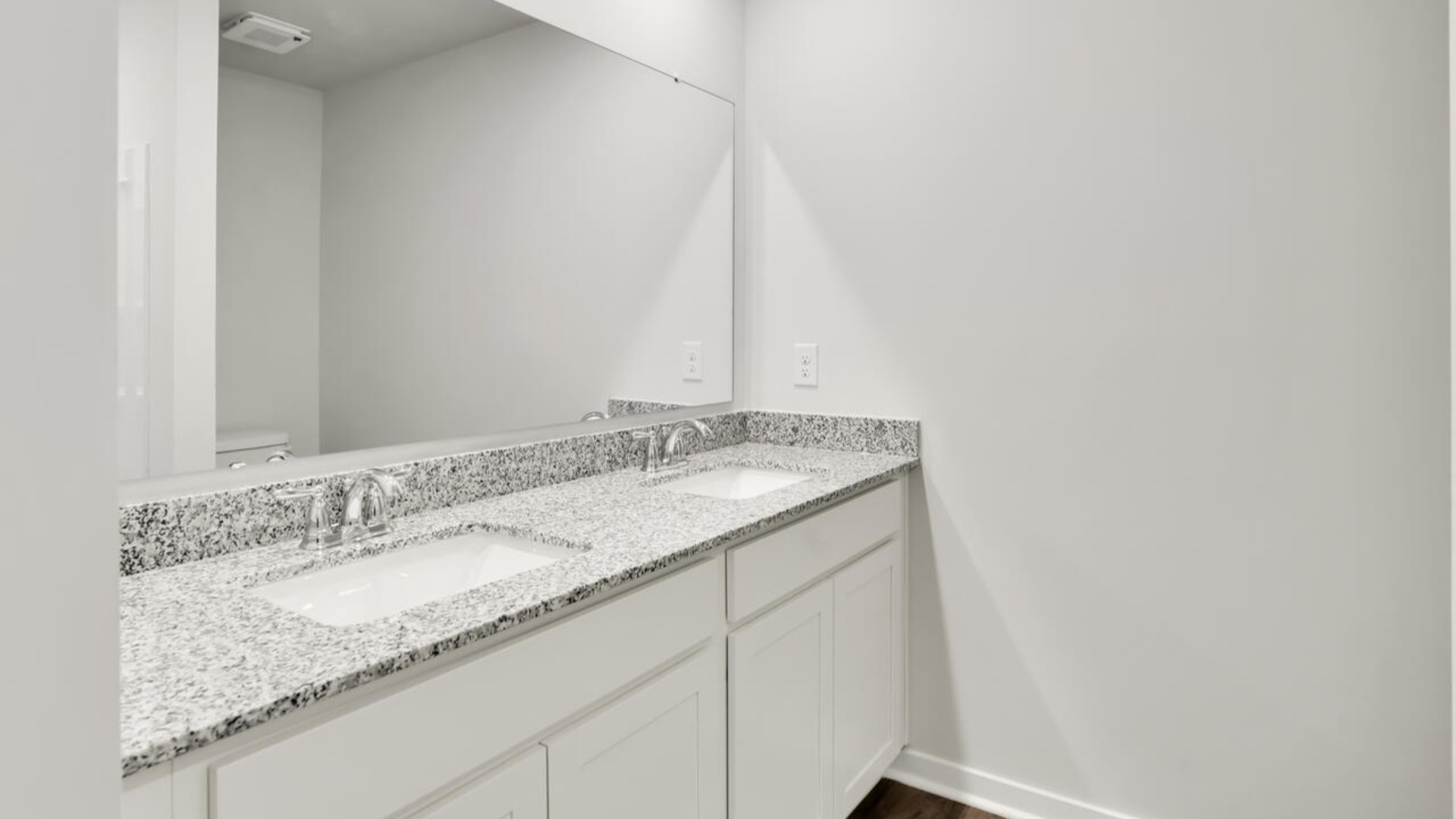 The primary bedroom features an ensuite bathroom with a double vanity, granite countertops, and walk-in closet.