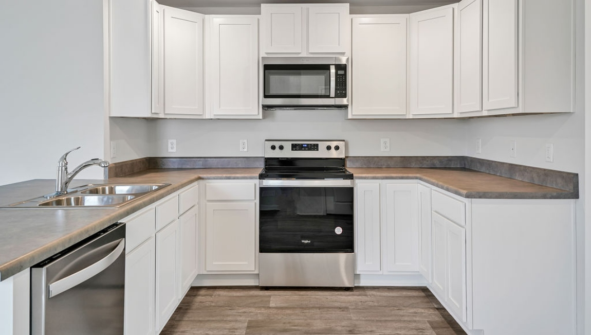 The kitchen is equipped for both efficiency and style with all stainless-steel appliances, including a range, built-in dishwasher, refrigerator, and microwave.