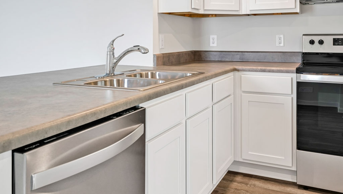 The kitchen is equipped for both efficiency and style with all stainless-steel appliances, including a range, built-in dishwasher, refrigerator, and microwave.