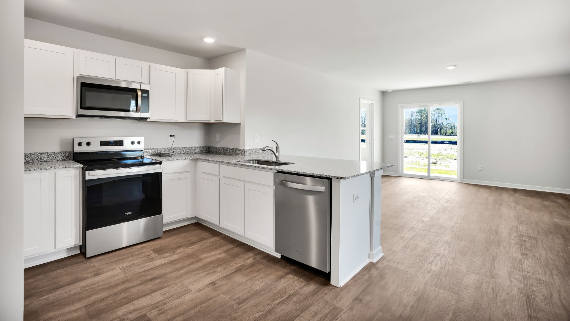 The kitchen is equipped for both efficiency and style with all stainless-steel appliances, including a range, built-in dishwasher, refrigerator, and microwave.