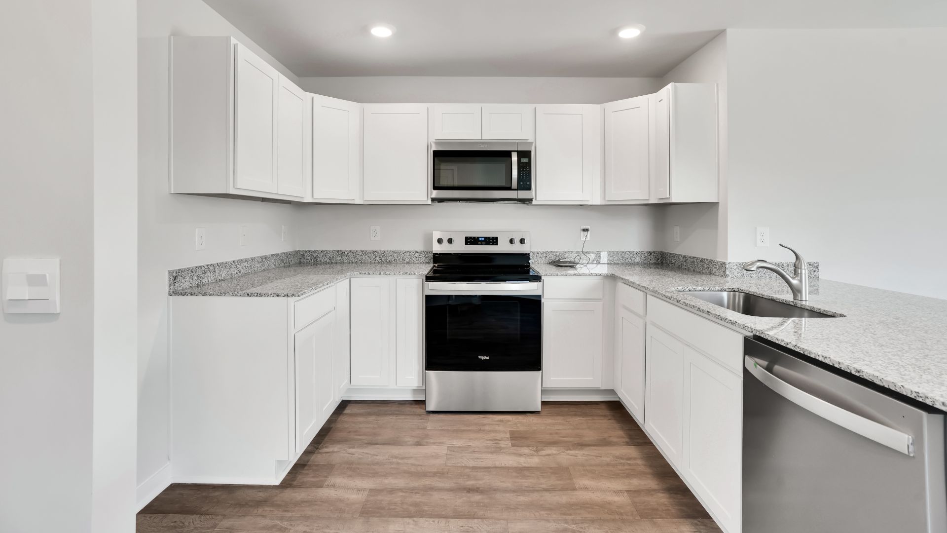 The kitchen is equipped for both efficiency and style with all stainless-steel appliances, including a range, built-in dishwasher, refrigerator, and microwave.