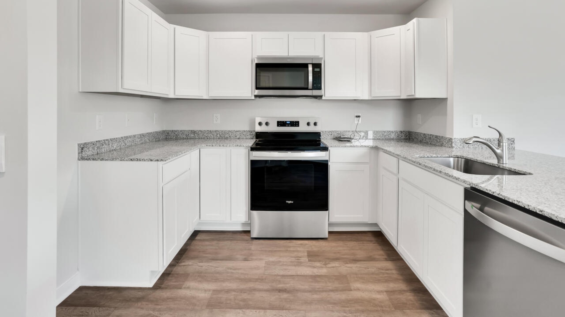 The kitchen is equipped for both efficiency and style with all stainless-steel appliances, including a range, built-in dishwasher, refrigerator, and microwave.