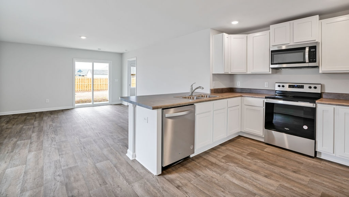 The kitchen is equipped for both efficiency and style with all stainless-steel appliances, including a range, built-in dishwasher, refrigerator, and microwave.