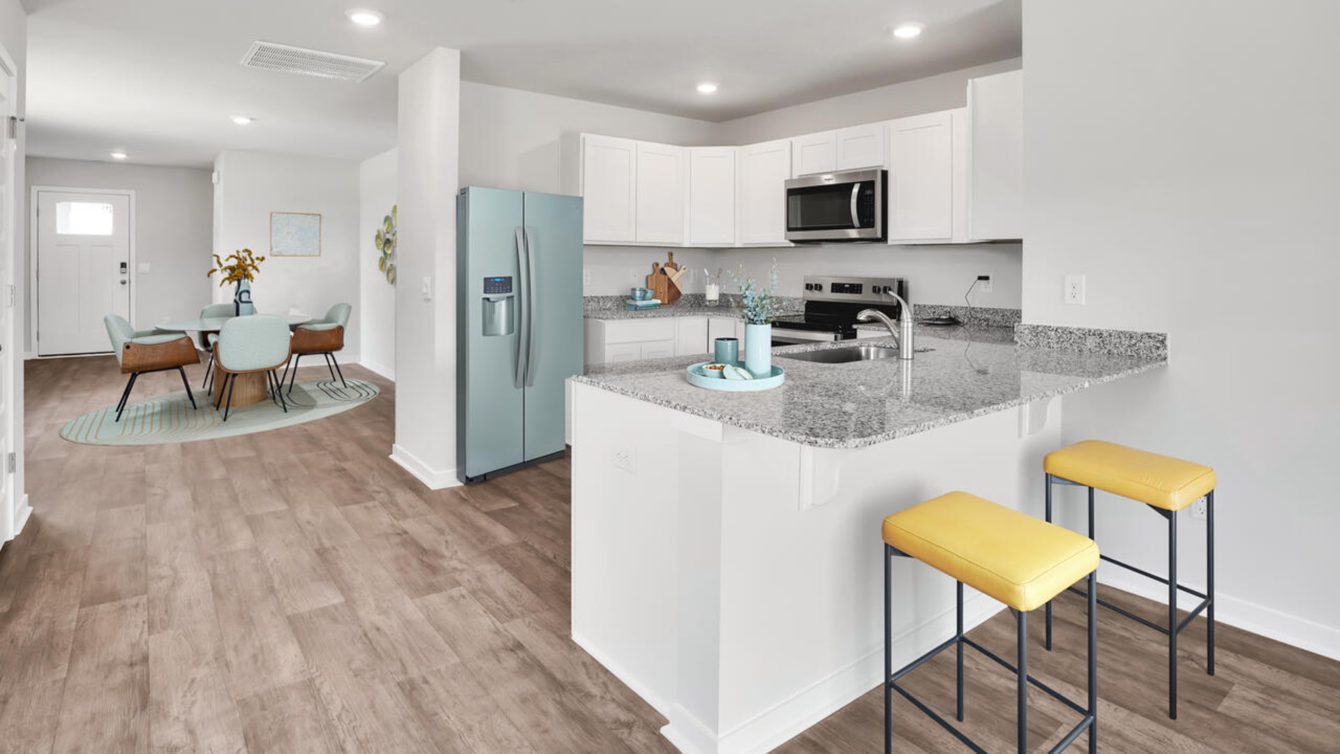 The kitchen is equipped for both efficiency and style with all stainless-steel appliances, including a range, built-in dishwasher, refrigerator, and microwave.