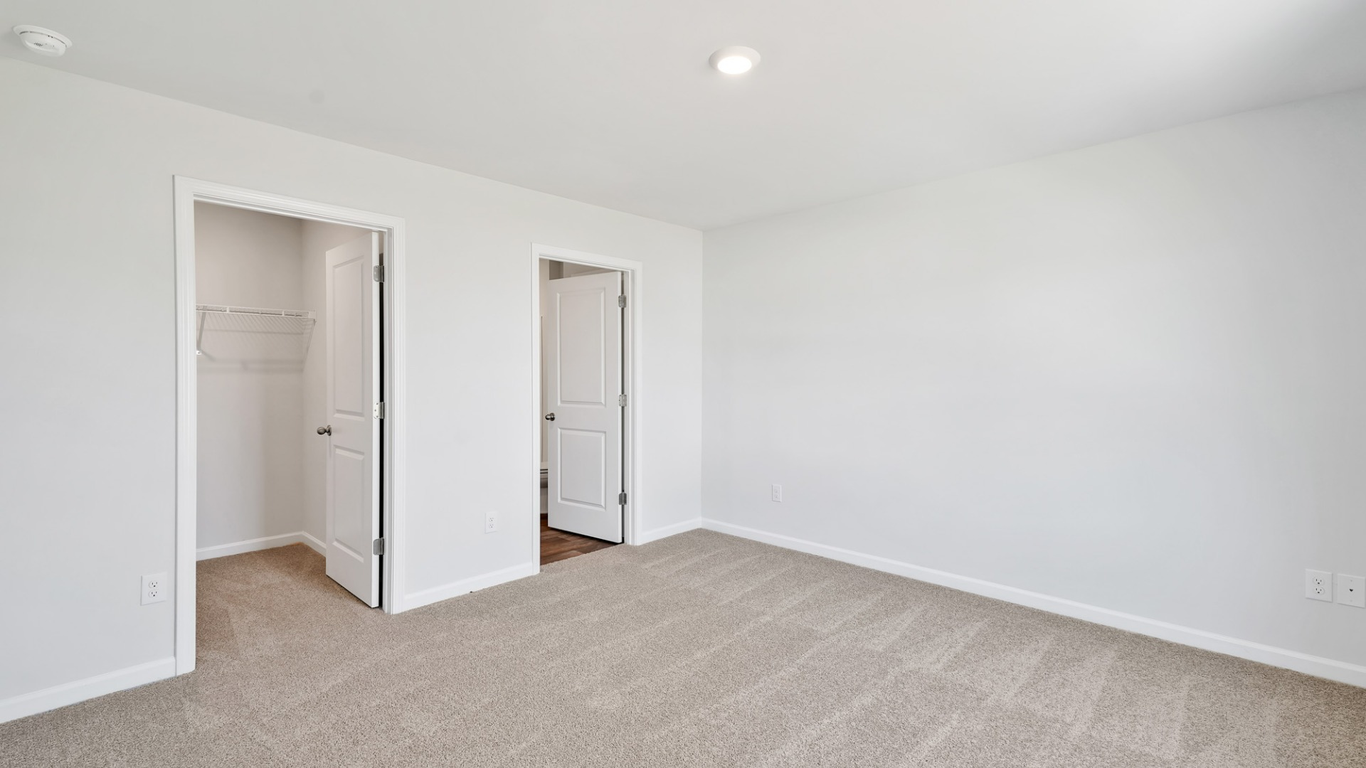 Nestled at the rear of the house, the primary bedroom has ample privacy. This layout is idea for those seeking practicality and relaxation in their living space.