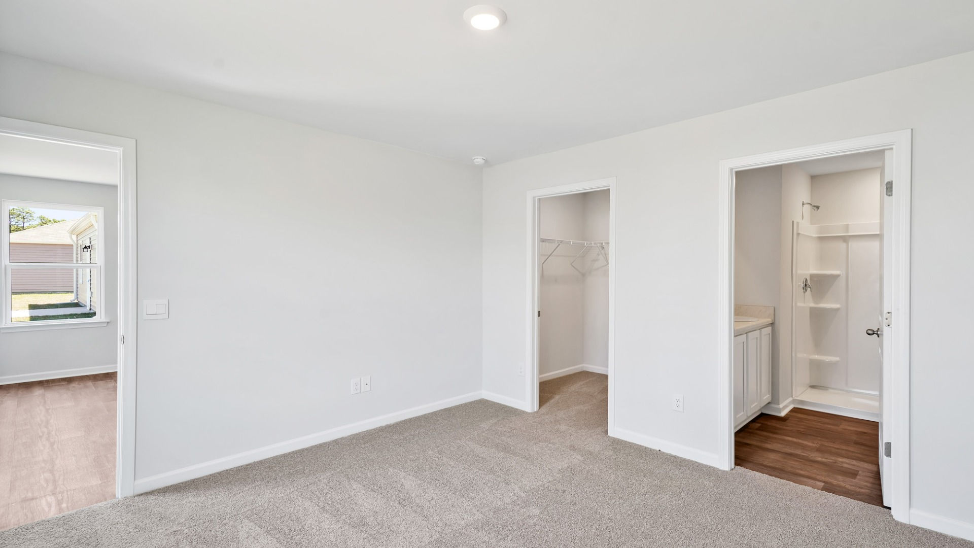 Nestled at the rear of the house, the primary bedroom has ample privacy. This layout is idea for those seeking practicality and relaxation in their living space.