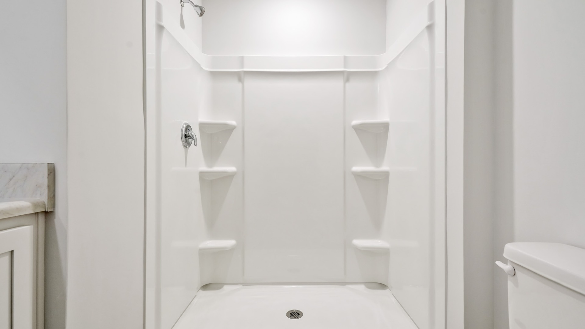 Nestled at the rear of the house, the primary bedroom has ample privacy. This layout is idea for those seeking practicality and relaxation in their living space.