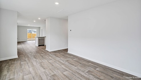 The kitchen is equipped for both efficiency and style with all stainless-steel appliances, including a range, built-in dishwasher, refrigerator, and microwave.