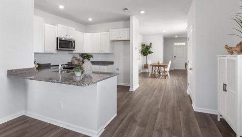 The kitchen is equipped for both efficiency and style with all stainless-steel appliances, including a range, built-in dishwasher, refrigerator, and microwave.
