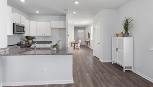 The kitchen is equipped for both efficiency and style with all stainless-steel appliances, including a range, built-in dishwasher, refrigerator, and microwave.