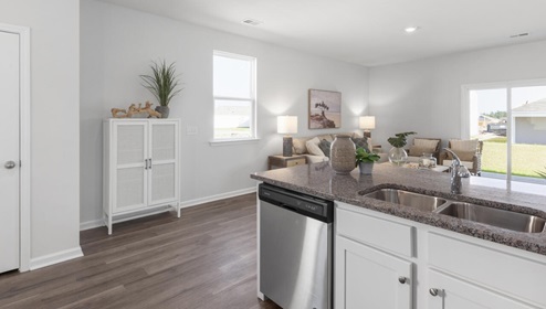 The kitchen is equipped for both efficiency and style with all stainless-steel appliances, including a range, built-in dishwasher, refrigerator, and microwave.
