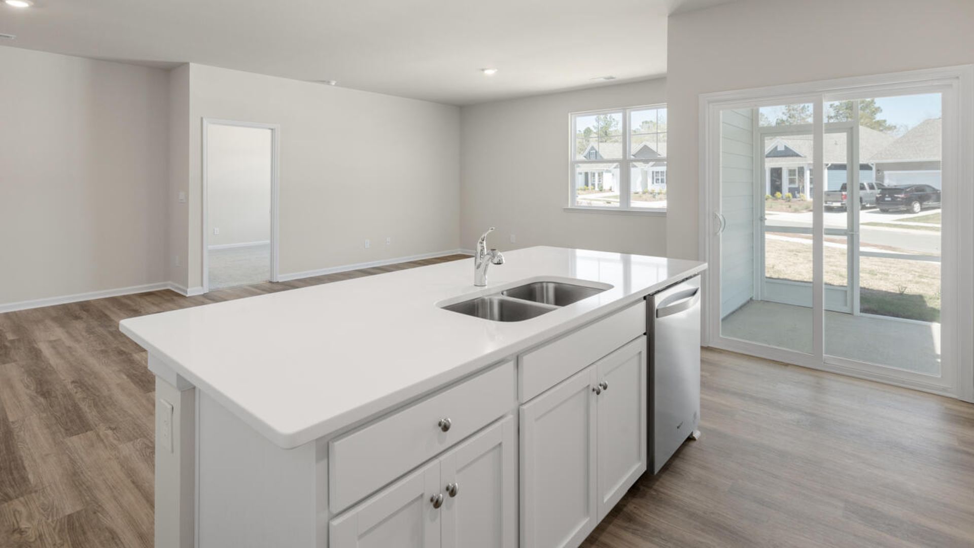 The open-concept family room, kitchen, and dining area feature granite countertops, stainless steel appliances, including a smooth-top range, dishwasher and overhead microwave.