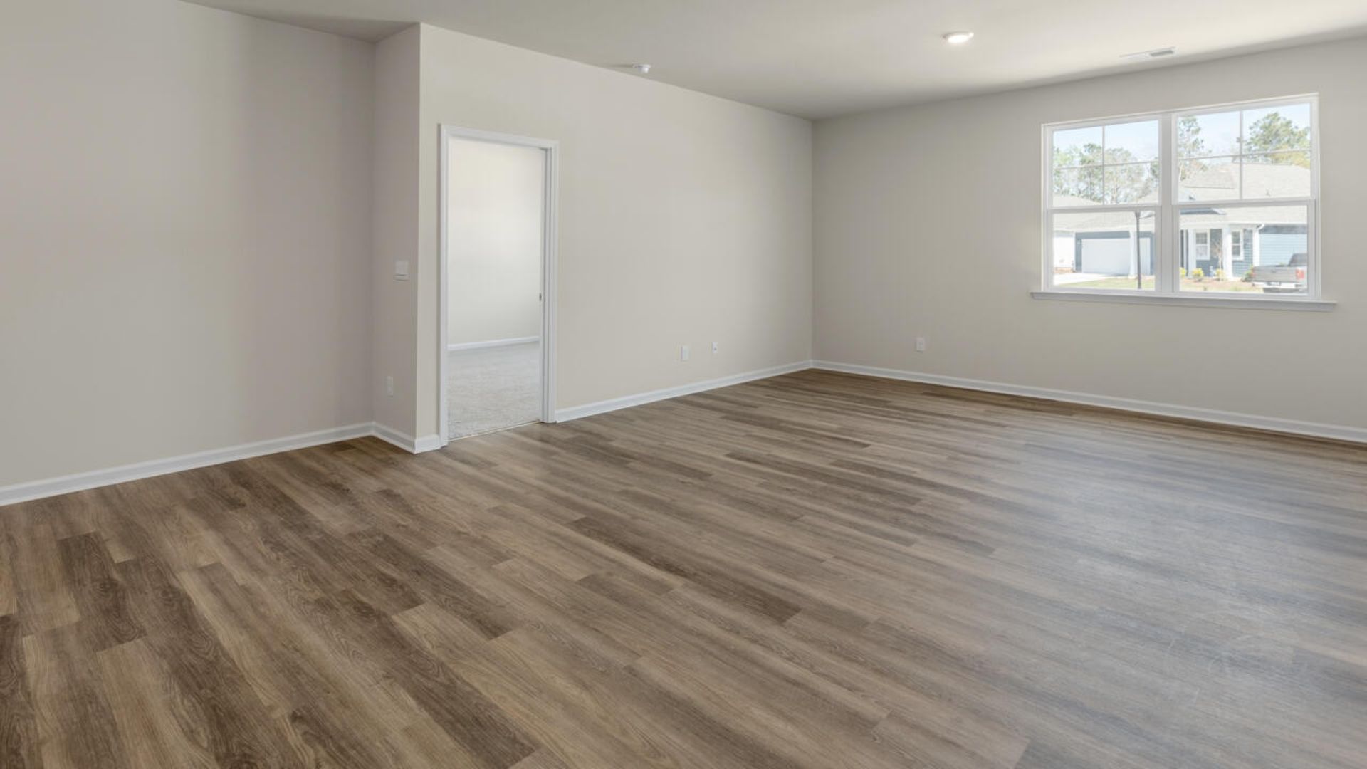 The open-concept family room, kitchen, and dining area feature granite countertops, stainless steel appliances, including a smooth-top range, dishwasher and overhead microwave.