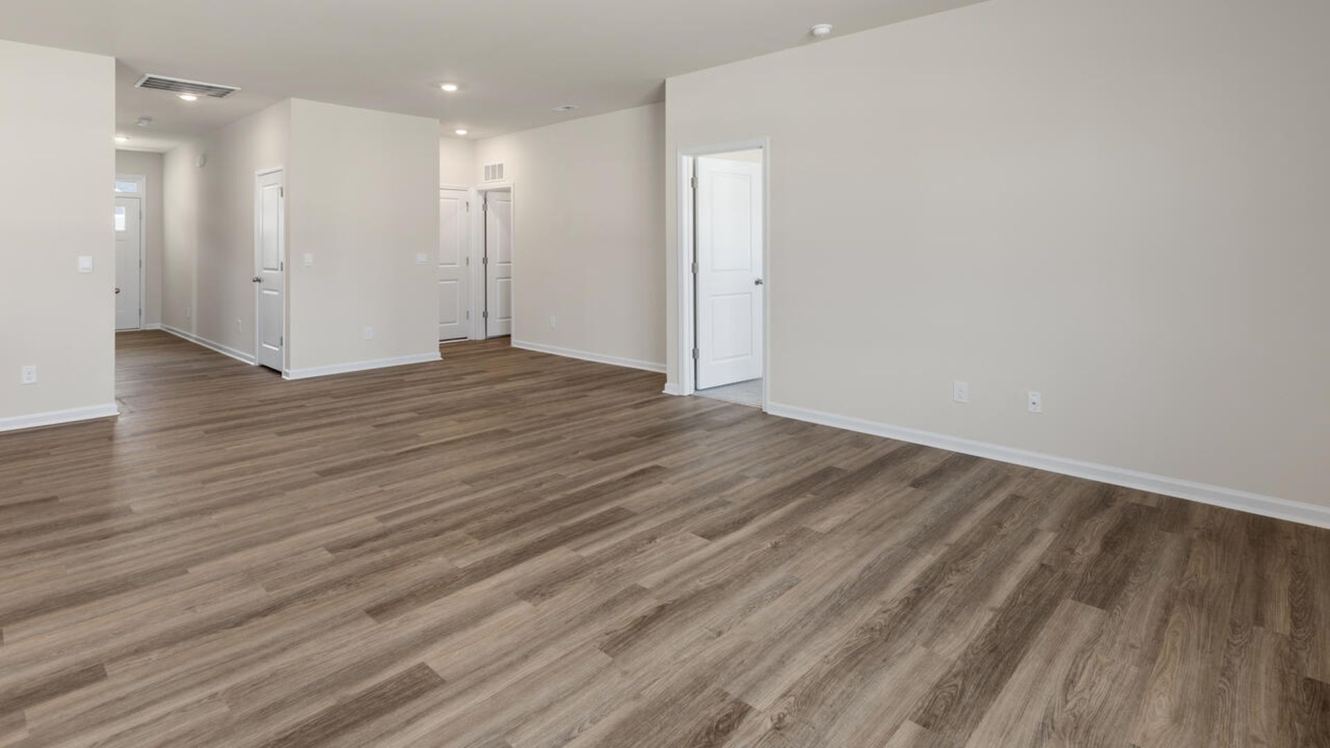 The open-concept family room, kitchen, and dining area feature granite countertops, stainless steel appliances, including a smooth-top range, dishwasher and overhead microwave.