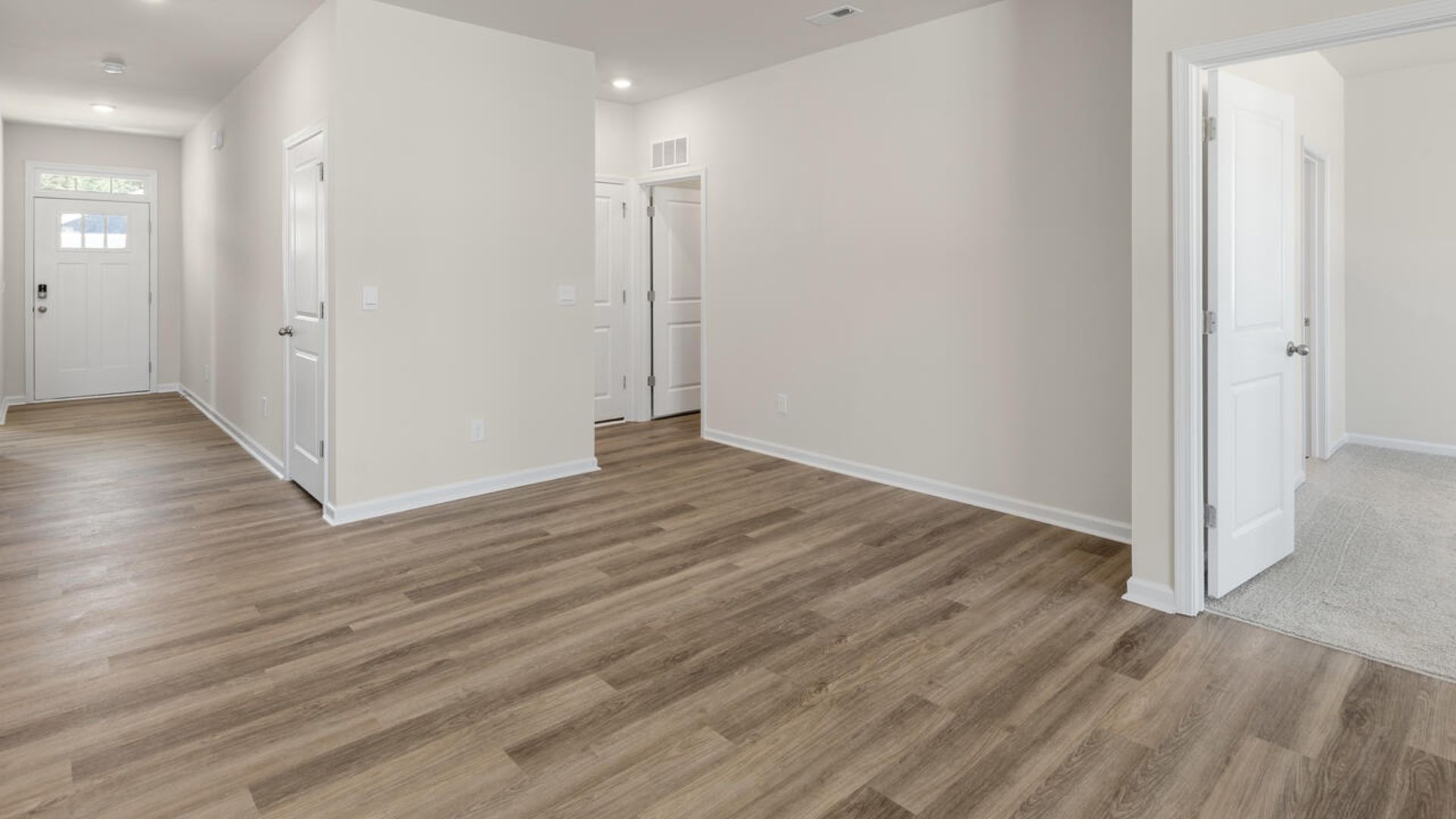 The open-concept family room, kitchen, and dining area feature granite countertops, stainless steel appliances, including a smooth-top range, dishwasher and overhead microwave.