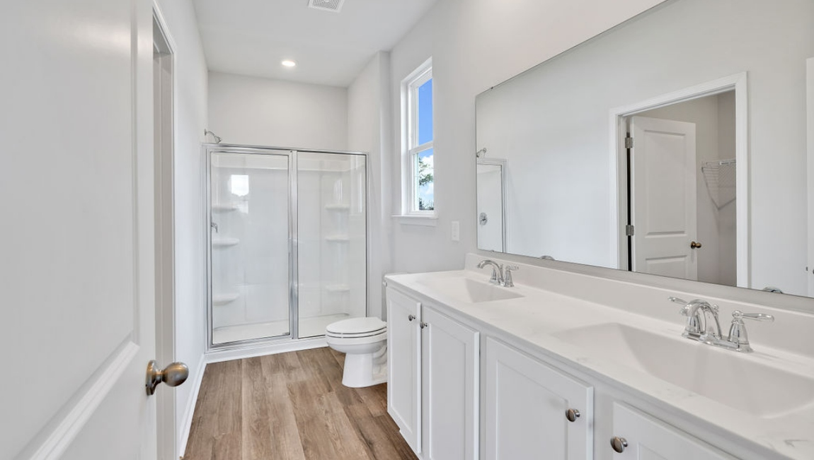 At the back, the Primary Suite provides privacy with a large walk-in closet and walk-in shower. This floor plan combines comfort and convenience, making it a great choice for those seeking an open layout and a 2-car garage.