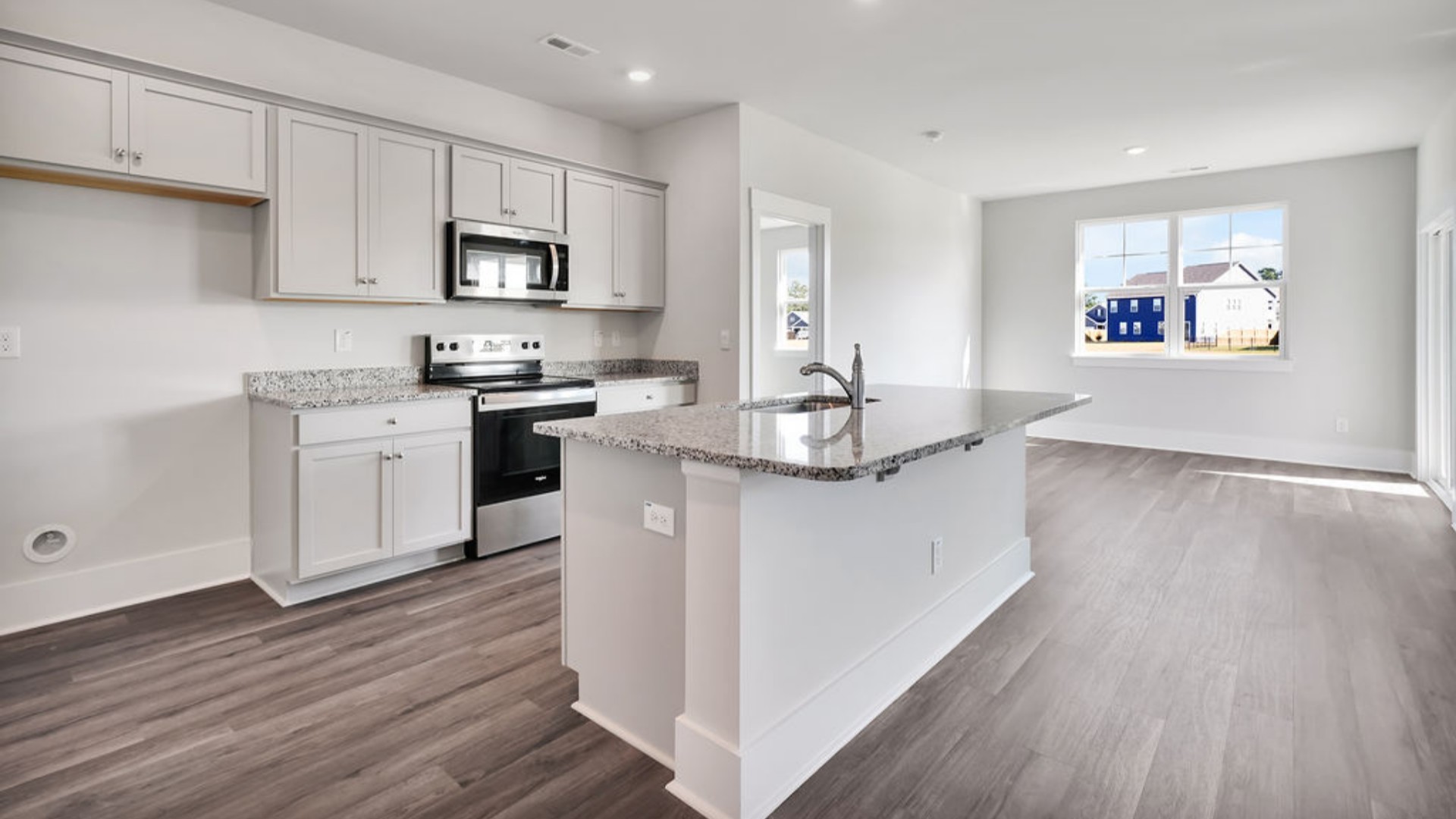 The kitchen features a large island, tile backsplash, quartz countertops, and stainless steel appliances, which are sure to both turn heads and make meal prep easy. You’ll never be too far from the action with the living and dining area right there.
