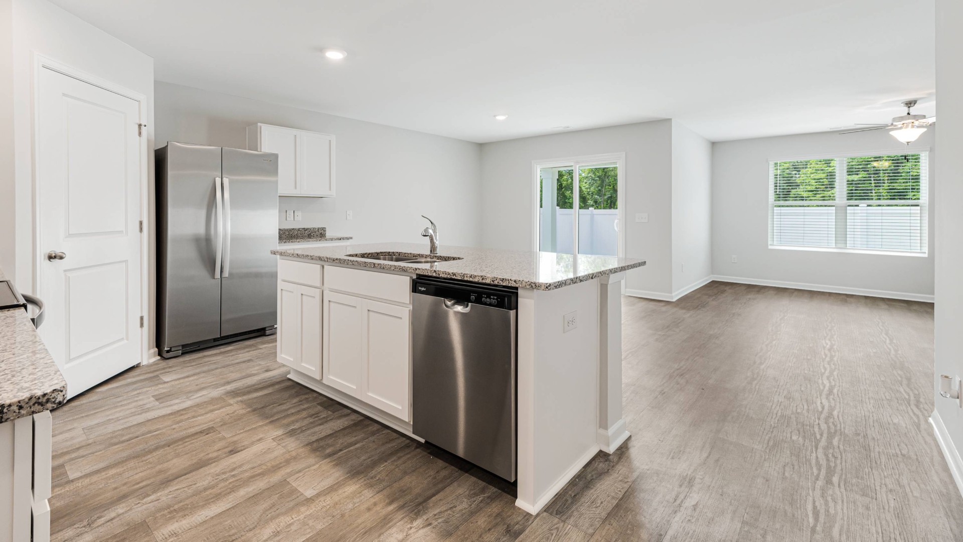 A fantastic kitchen featuring Whirlpool Stainless Steel Appliances with a smooth-top electric range, microwave, dishwasher.