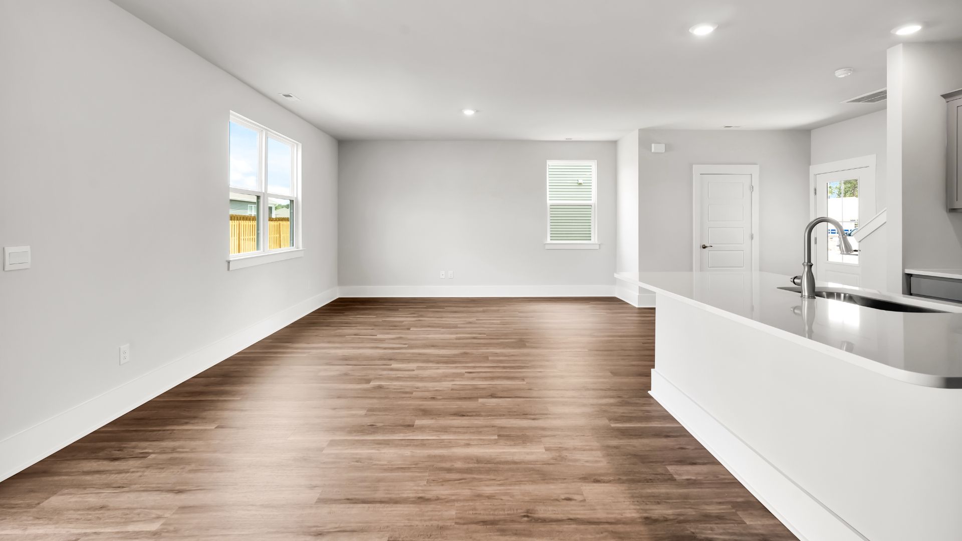 This impressive space features a family room, dining area, and modern kitchen. The kitchen is equipped with a pantry, stainless steel appliances, and a large island with a breakfast bar, making it perfect for both cooking and entertaining.