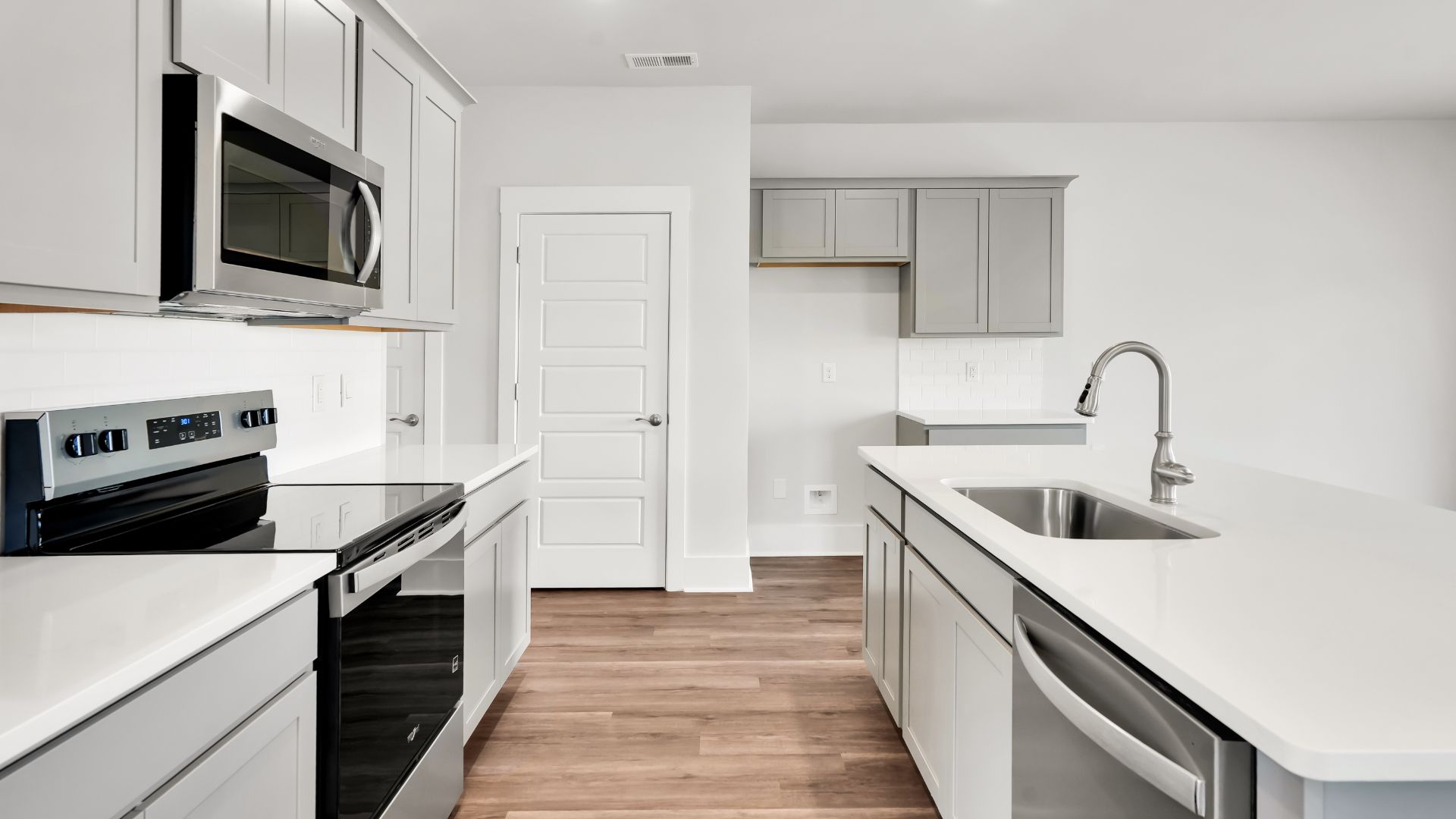 This impressive space features a family room, dining area, and modern kitchen. The kitchen is equipped with a pantry, stainless steel appliances, and a large island with a breakfast bar, making it perfect for both cooking and entertaining.