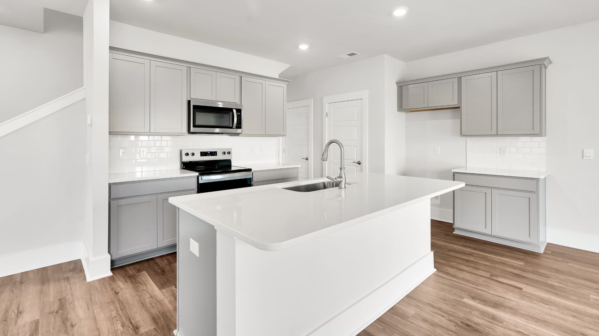 This impressive space features a family room, dining area, and modern kitchen. The kitchen is equipped with a pantry, stainless steel appliances, and a large island with a breakfast bar, making it perfect for both cooking and entertaining.