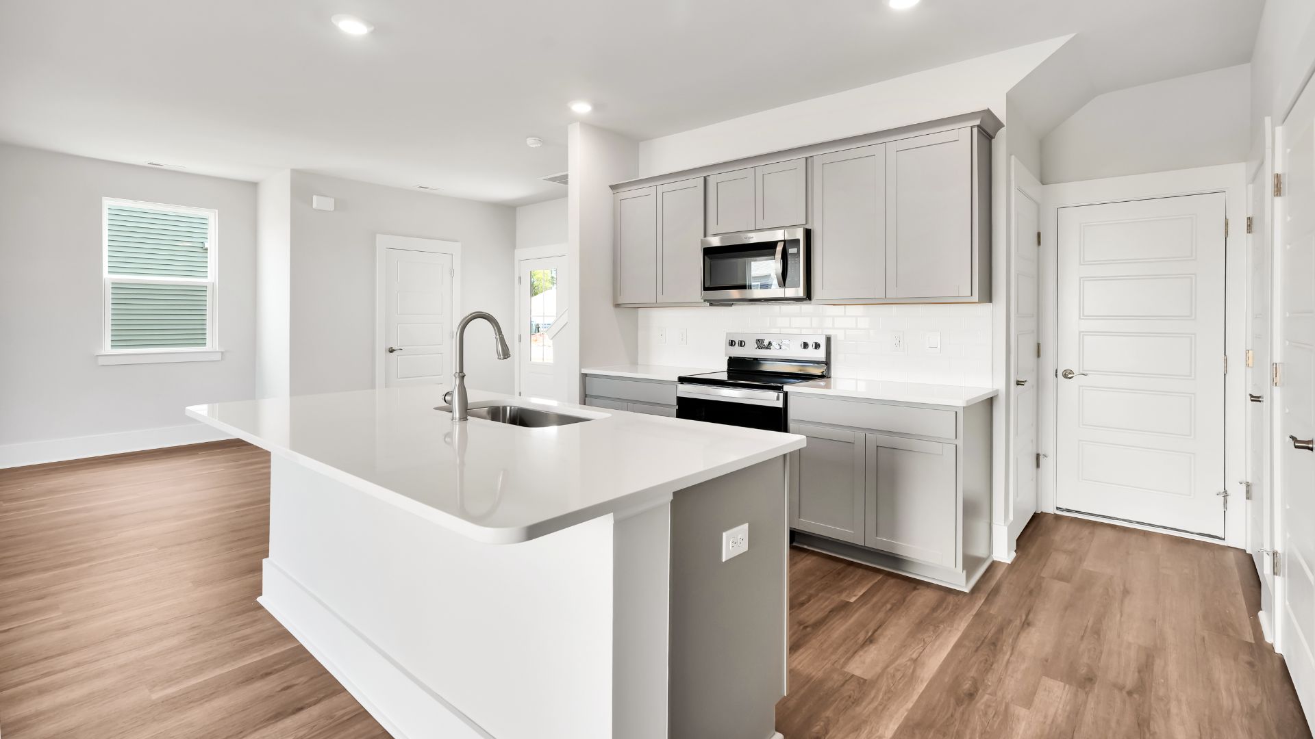 This impressive space features a family room, dining area, and modern kitchen. The kitchen is equipped with a pantry, stainless steel appliances, and a large island with a breakfast bar, making it perfect for both cooking and entertaining.