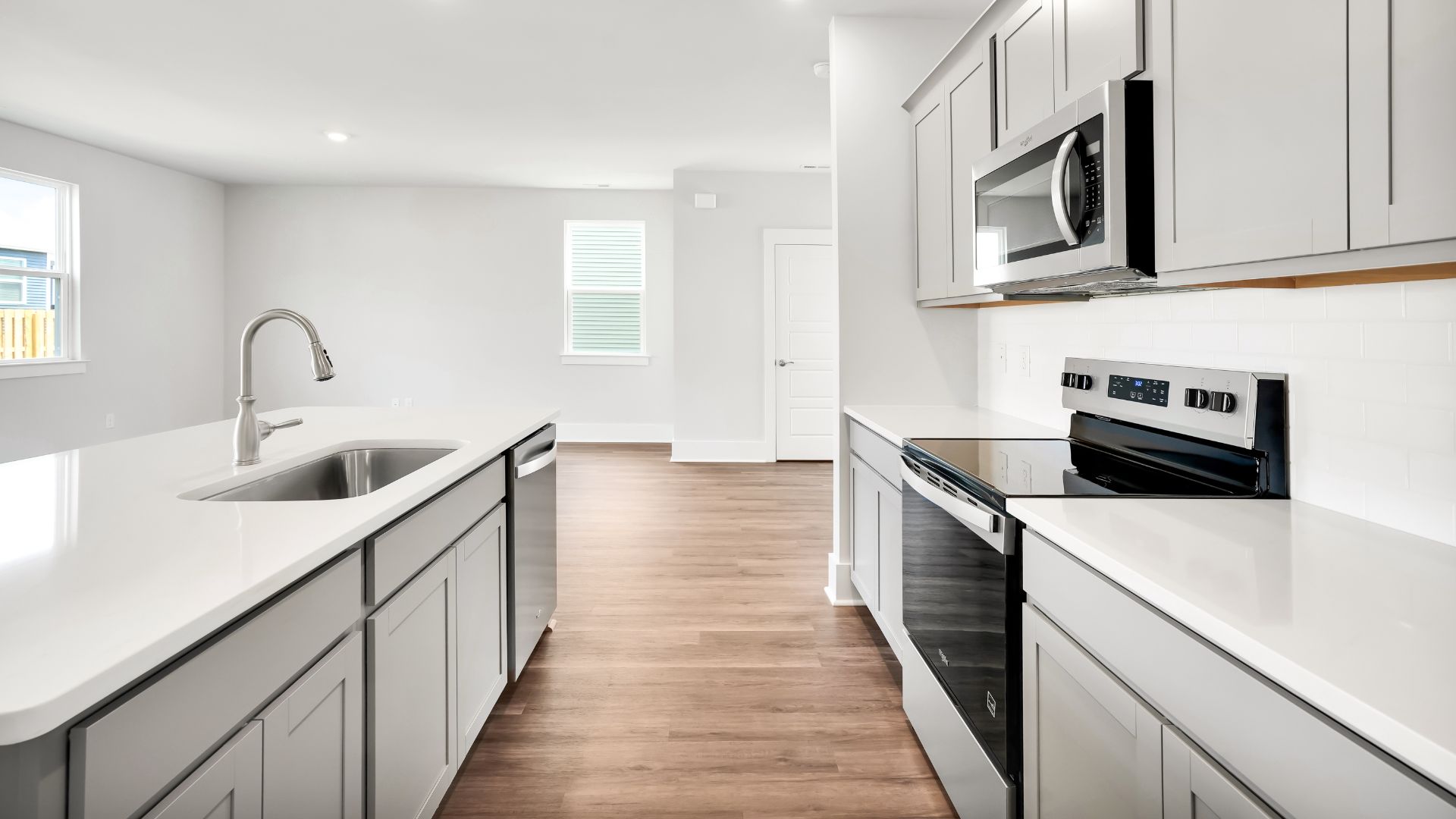This impressive space features a family room, dining area, and modern kitchen. The kitchen is equipped with a pantry, stainless steel appliances, and a large island with a breakfast bar, making it perfect for both cooking and entertaining.