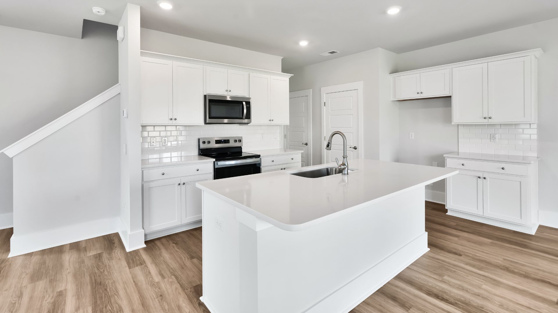 The kitchen features shaker-style cabinets, granite countertops, and stainless steel appliances, which are sure to both turn heads and make meal prep easy