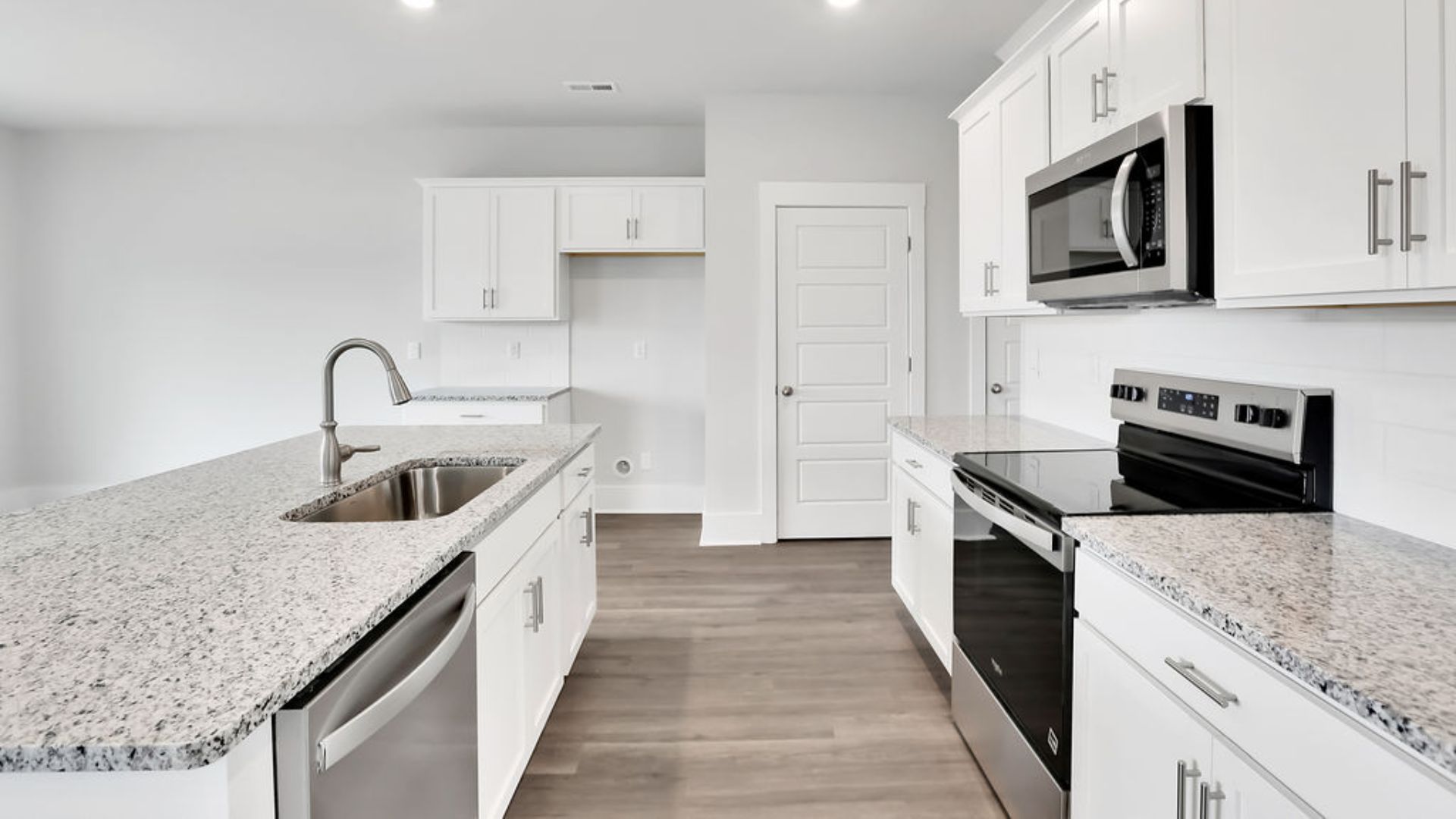 The kitchen features shaker-style cabinets, granite countertops, and stainless steel appliances, which are sure to both turn heads and make meal prep easy.