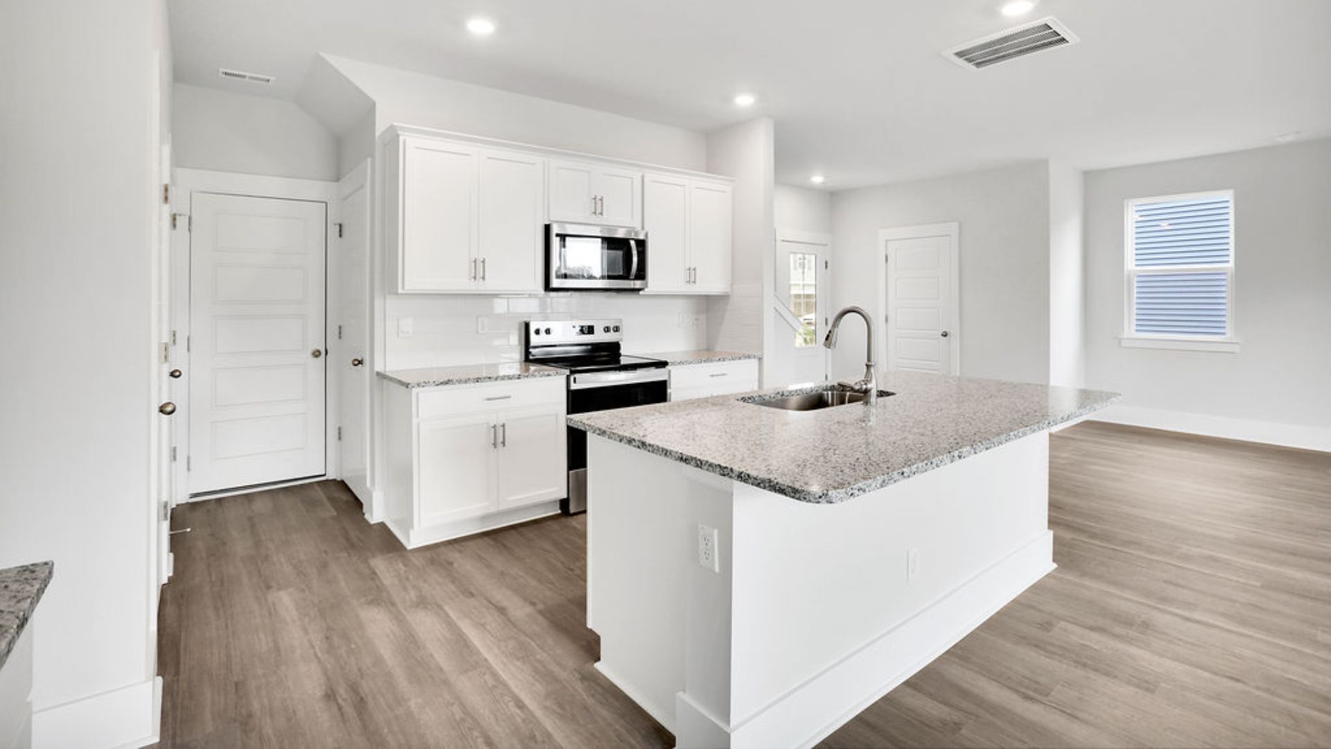 The kitchen features shaker-style cabinets, granite countertops, and stainless steel appliances, which are sure to both turn heads and make meal prep easy. You’ll never be too far from the action with the living and dining area right there.