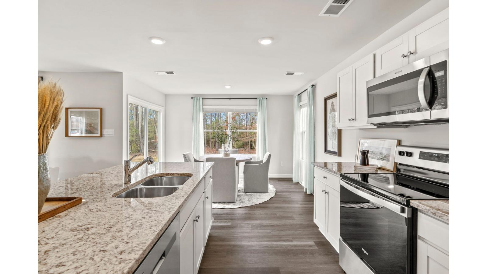 The spacious kitchen has a large island with room for seating, an impressive corner pantry, plenty of cabinet space and stainless-steel appliances. The kitchen has an eat-in dining area with a sliding glass door for easy access to the backyard.