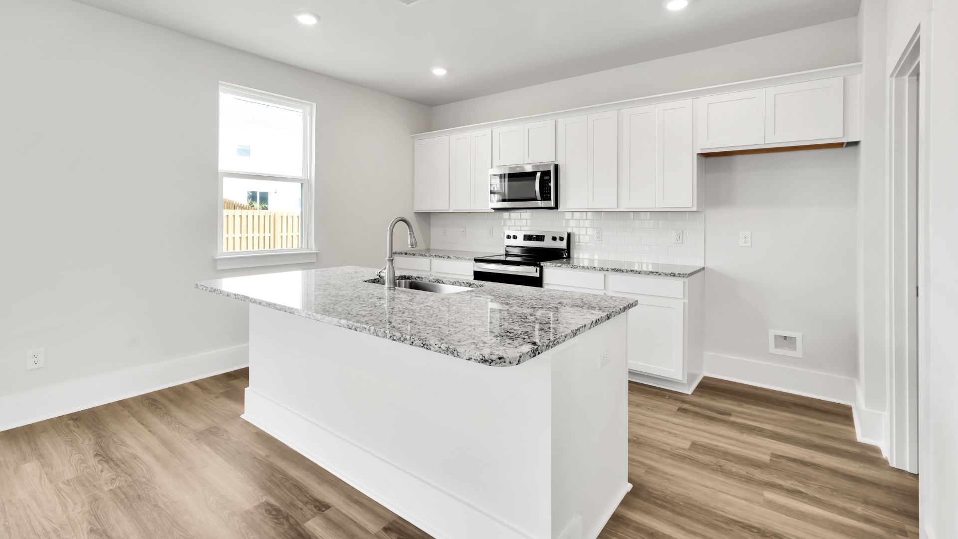 The kitchen features a large island and stainless steel appliances, which are sure to both turn heads and make meal prep easy. You’ll never be too far from the action with the living and dining area right there.