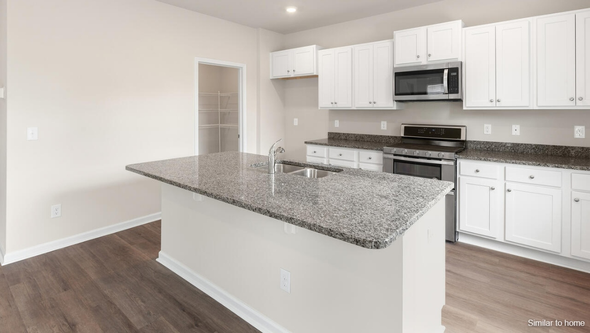 The kitchen features a large island and stainless steel appliances, which are sure to both turn heads and make meal prep easy. You’ll never be too far from the action with the living and dining area right there.