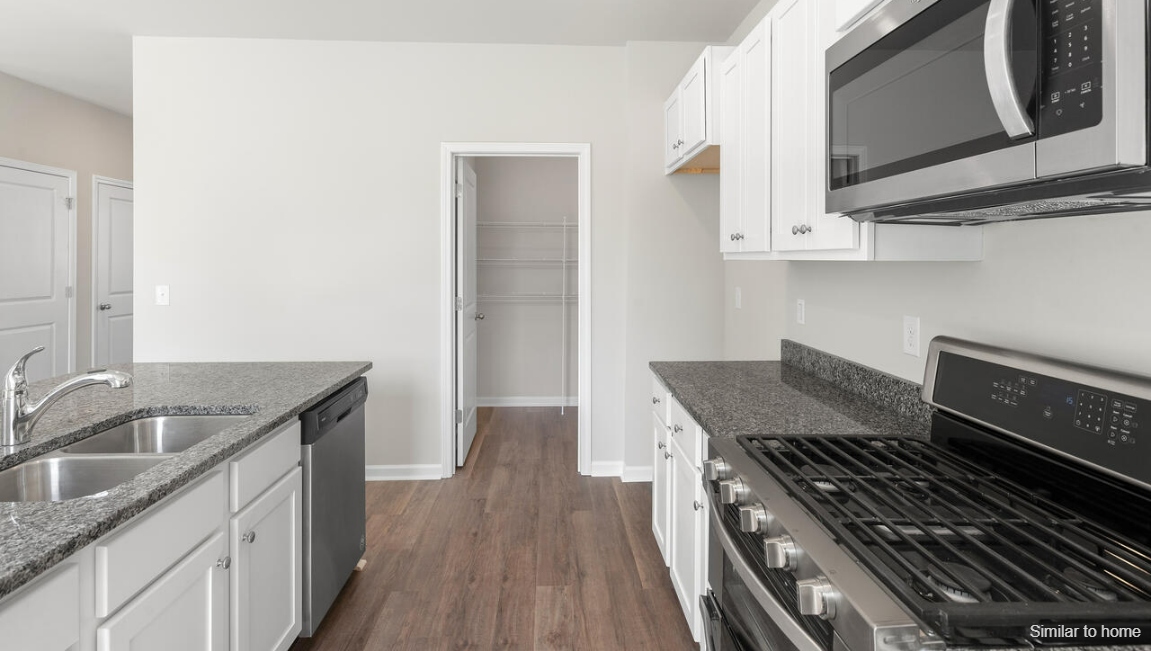 The kitchen features a large island and stainless steel appliances, which are sure to both turn heads and make meal prep easy. You’ll never be too far from the action with the living and dining area right there.