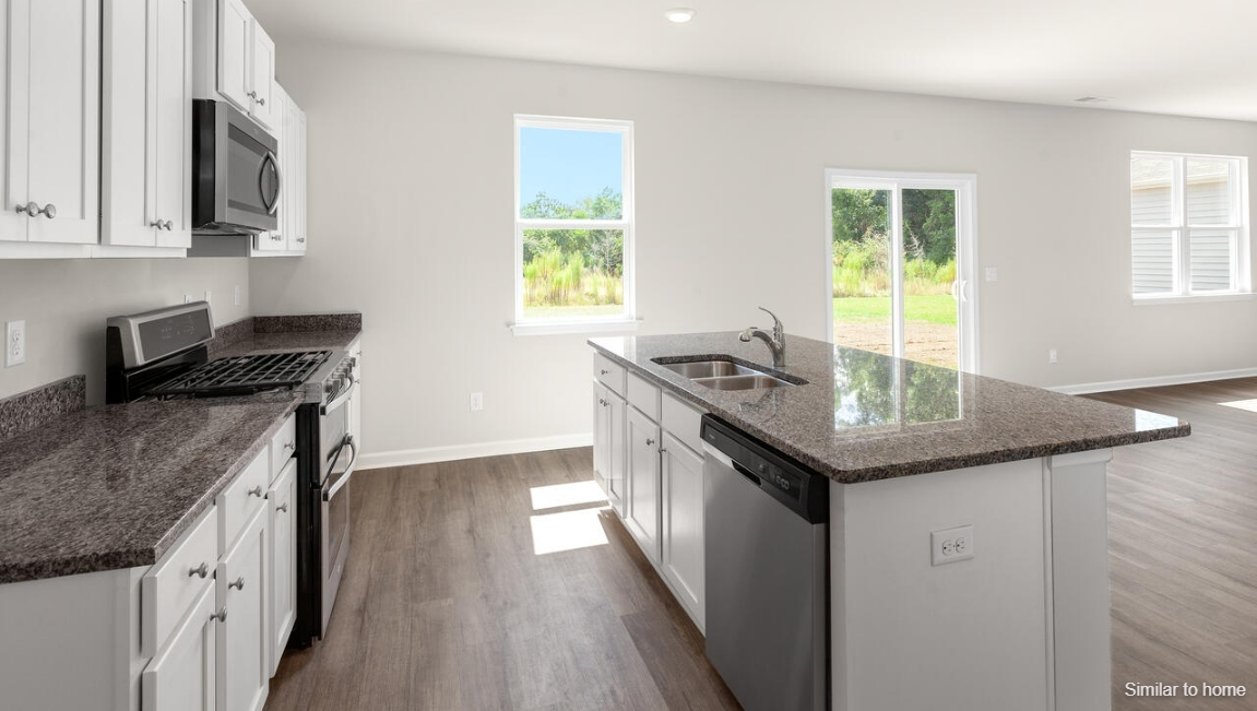 The kitchen features a large island and stainless steel appliances, which are sure to both turn heads and make meal prep easy. You’ll never be too far from the action with the living and dining area right there.