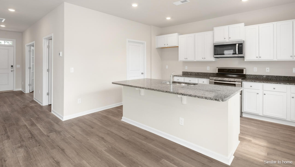 The kitchen features a large island and stainless steel appliances, which are sure to both turn heads and make meal prep easy. You’ll never be too far from the action with the living and dining area right there.