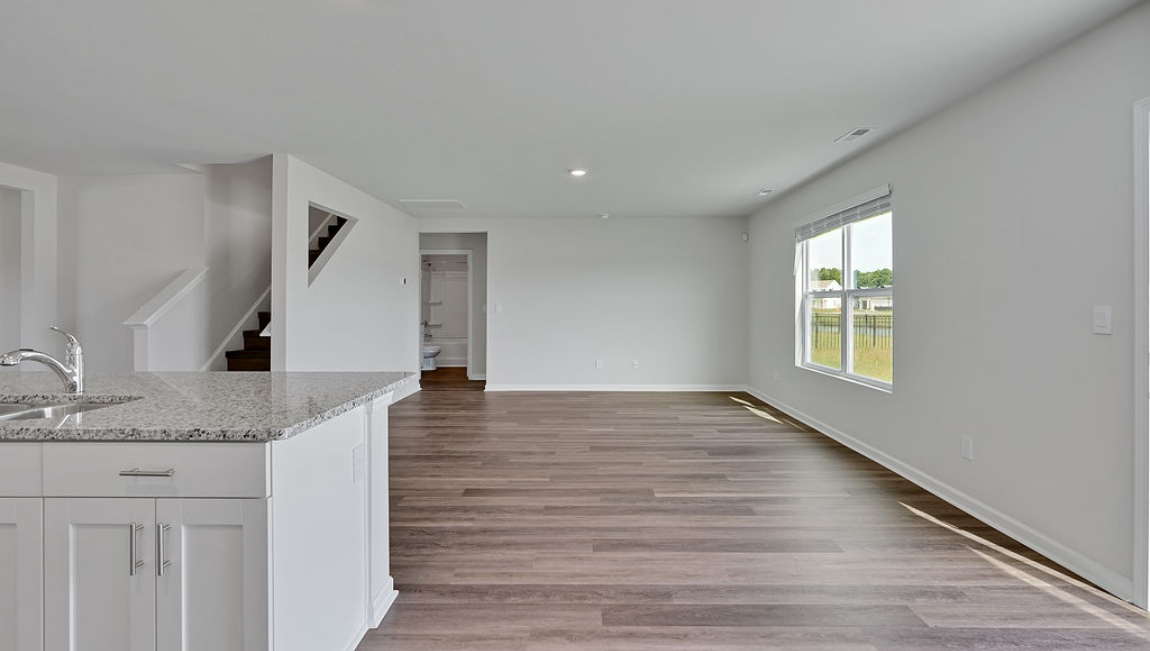 The gourmet kitchen has an oversized island for extra seating and a large pantry, and it opens to the dining area and a spacious living room