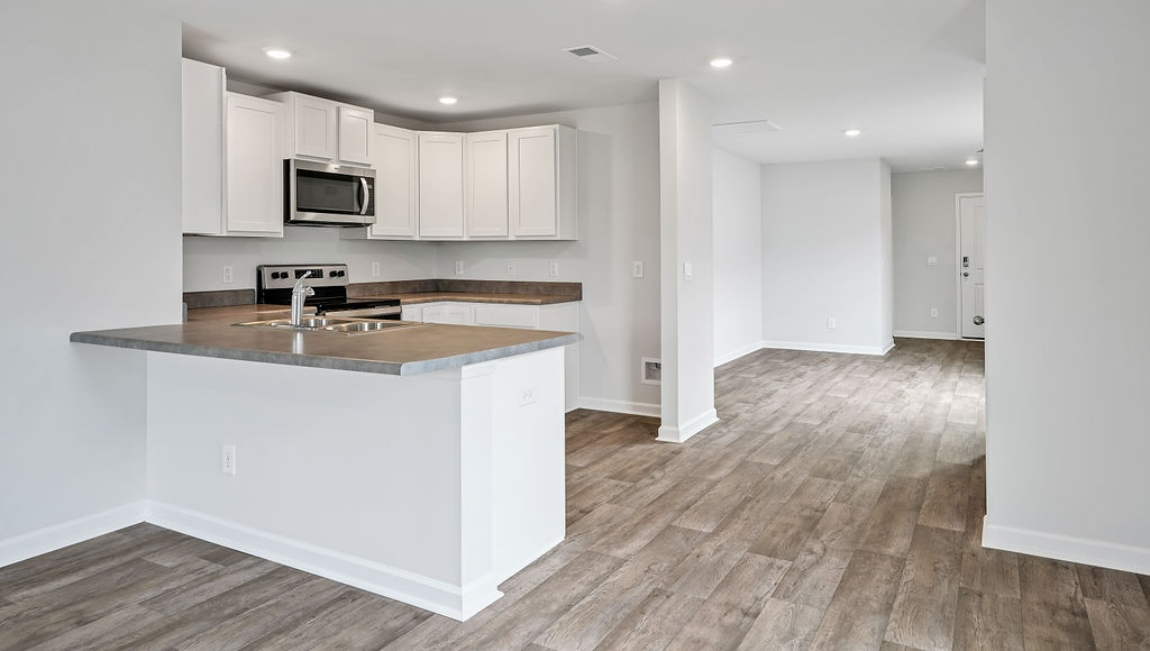 The kitchen is equipped for both efficiency and style with all stainless-steel appliances, including a range, built-in dishwasher, refrigerator, and microwave.