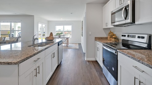 The kitchen features a large island, granite countertops, and stainless steel appliances, which are sure to both turn heads and make meal prep easy. You’ll never be too far from the action with the living and dining area right there.
