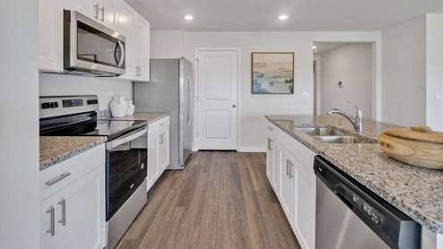 The kitchen features a large island, granite countertops, and stainless steel appliances, which are sure to both turn heads and make meal prep easy. You’ll never be too far from the action with the living and dining area right there.