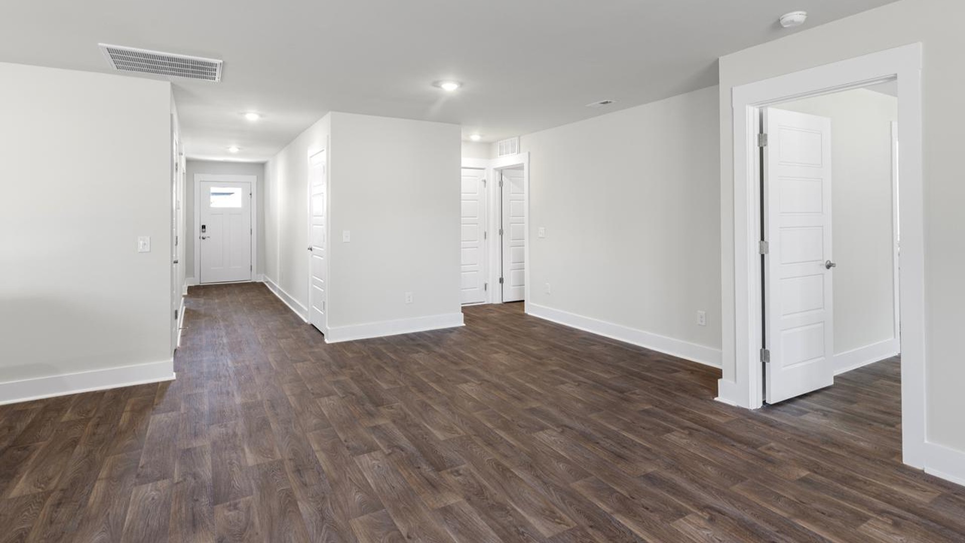The open-concept family room, kitchen, and dining area feature granite countertops, stainless steel appliances, including a smooth-top range, dishwasher and overhead microwave.