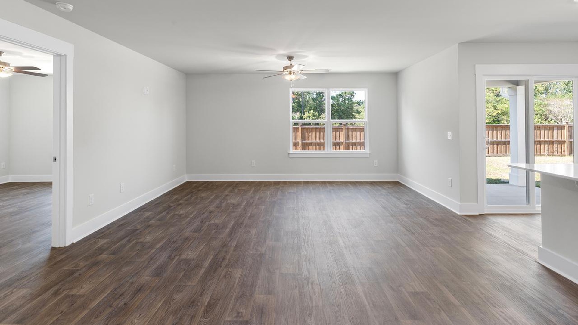 The open-concept family room, kitchen, and dining area feature granite countertops, stainless steel appliances, including a smooth-top range, dishwasher and overhead microwave.